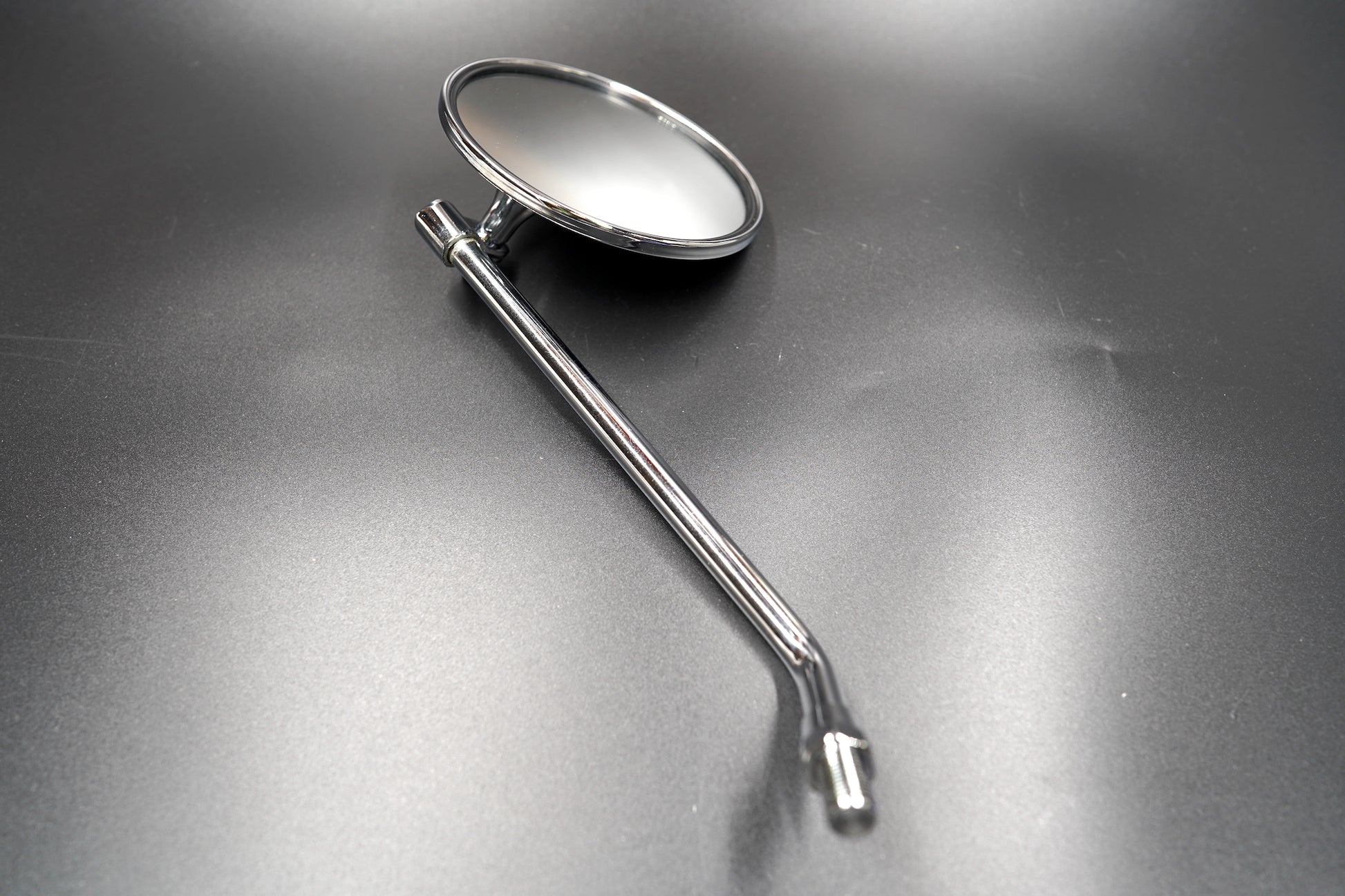 Side angle of chrome mirror showcasing arm and mount

