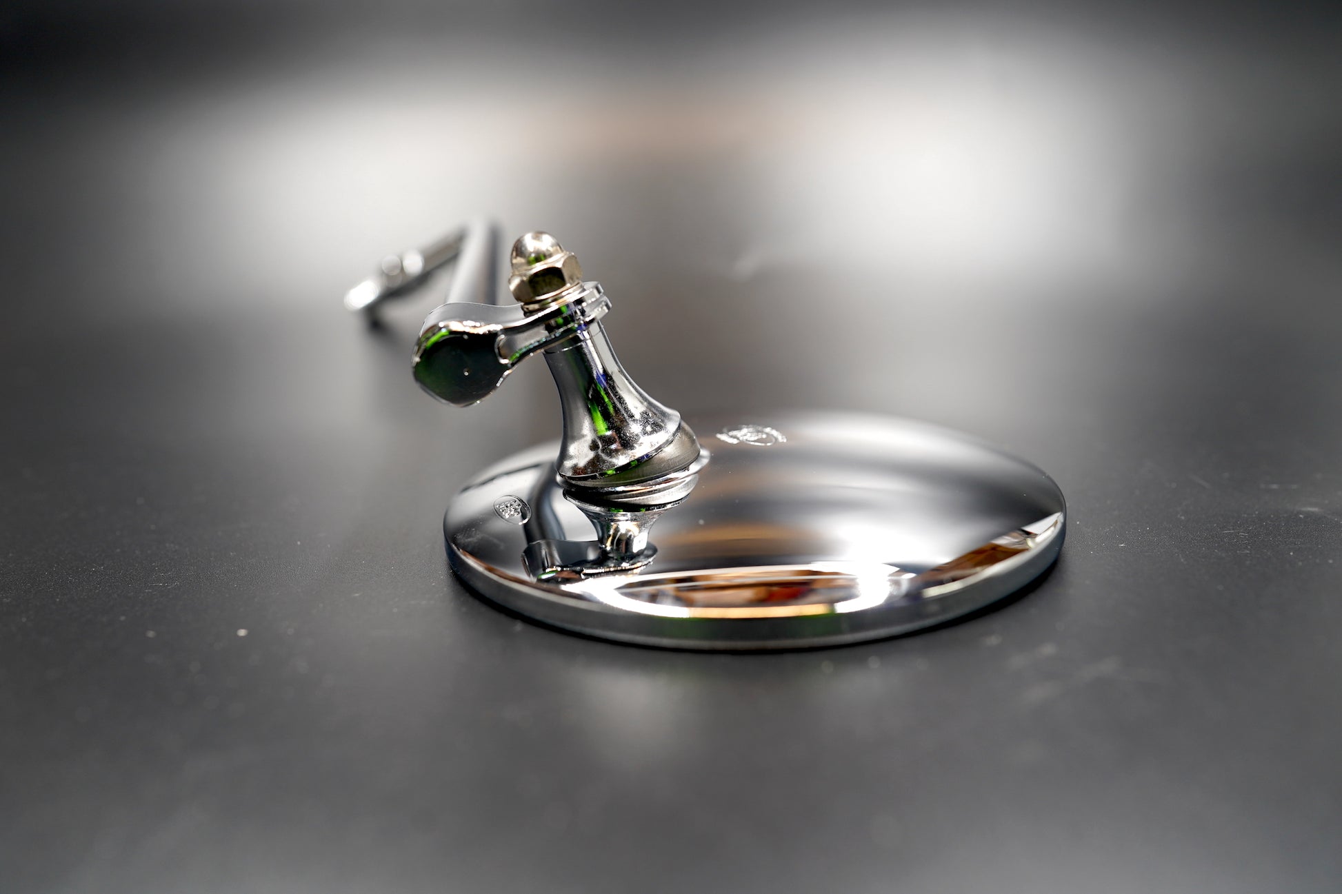 Close-up of chrome motorcycle mirror glass and rim

