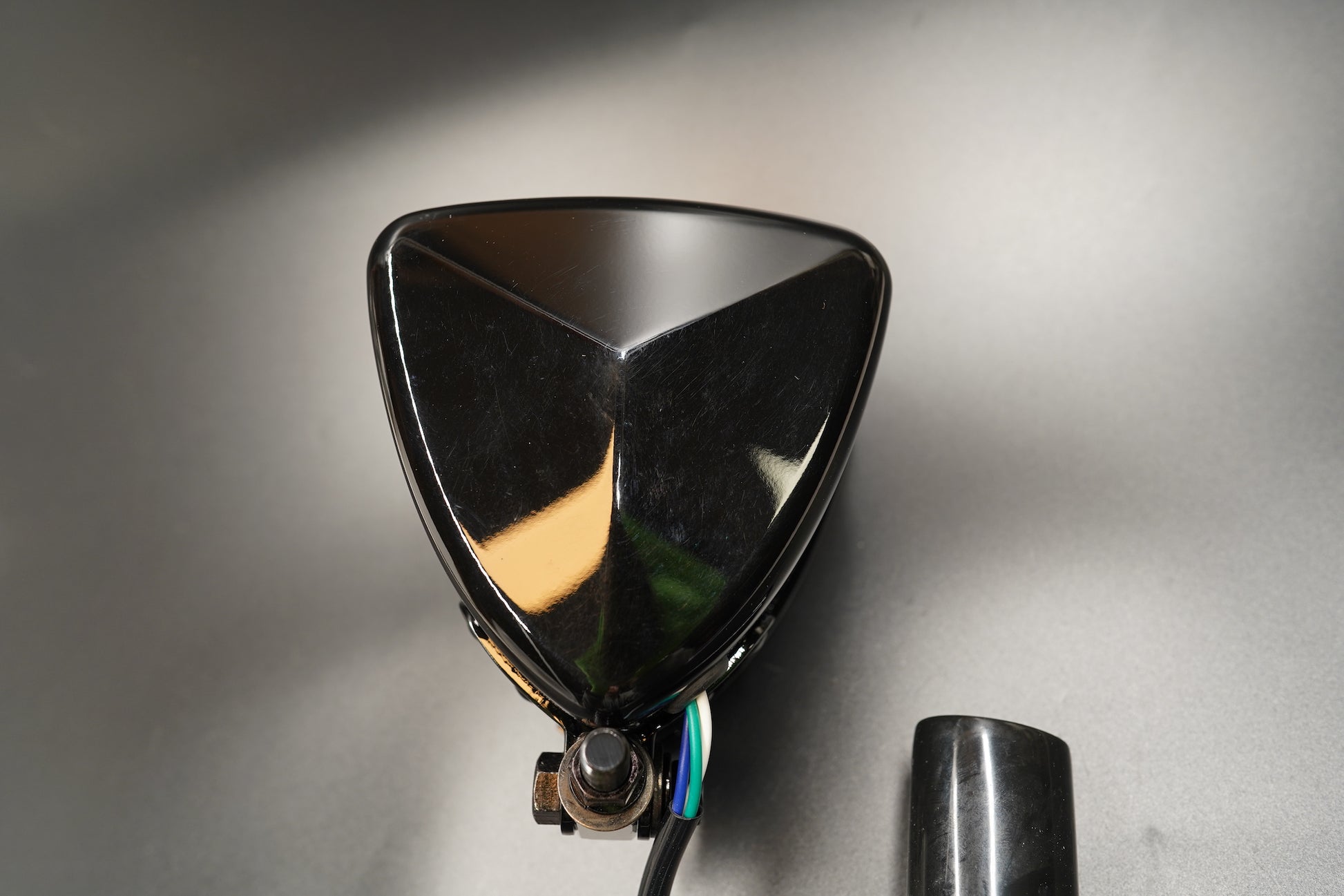 Black gloss side showing clean silhouette under soft light.