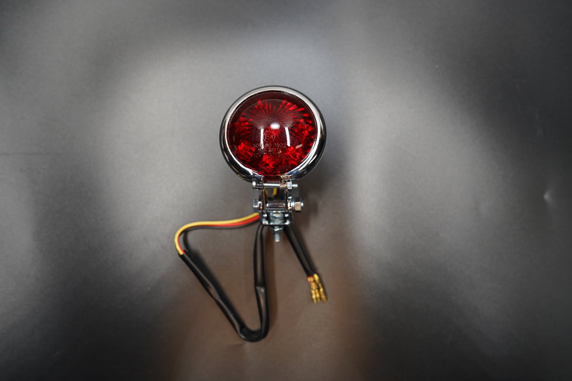 Front main view of vintage-style round LED tail light — domed red lens with matte black metal housing.