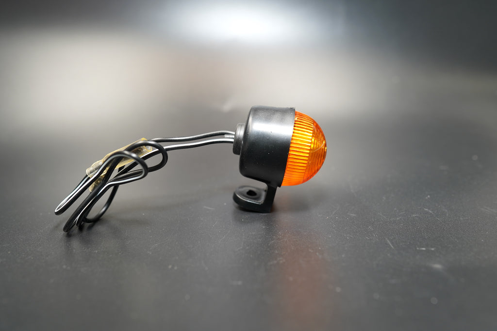 Close-up of single amber turn signal highlighting impact-resistant polycarbonate lens.