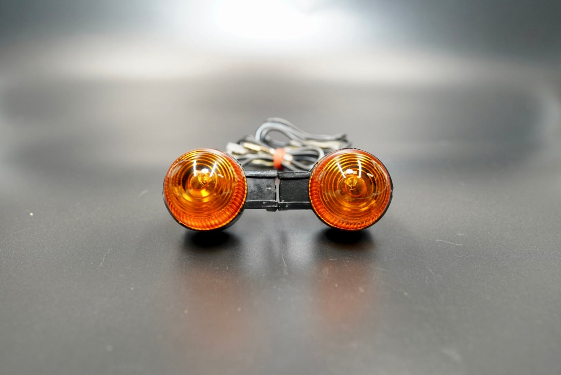 Front view of amber bullet motorcycle turn signals — classic pair design with rubber stems and amber lenses.