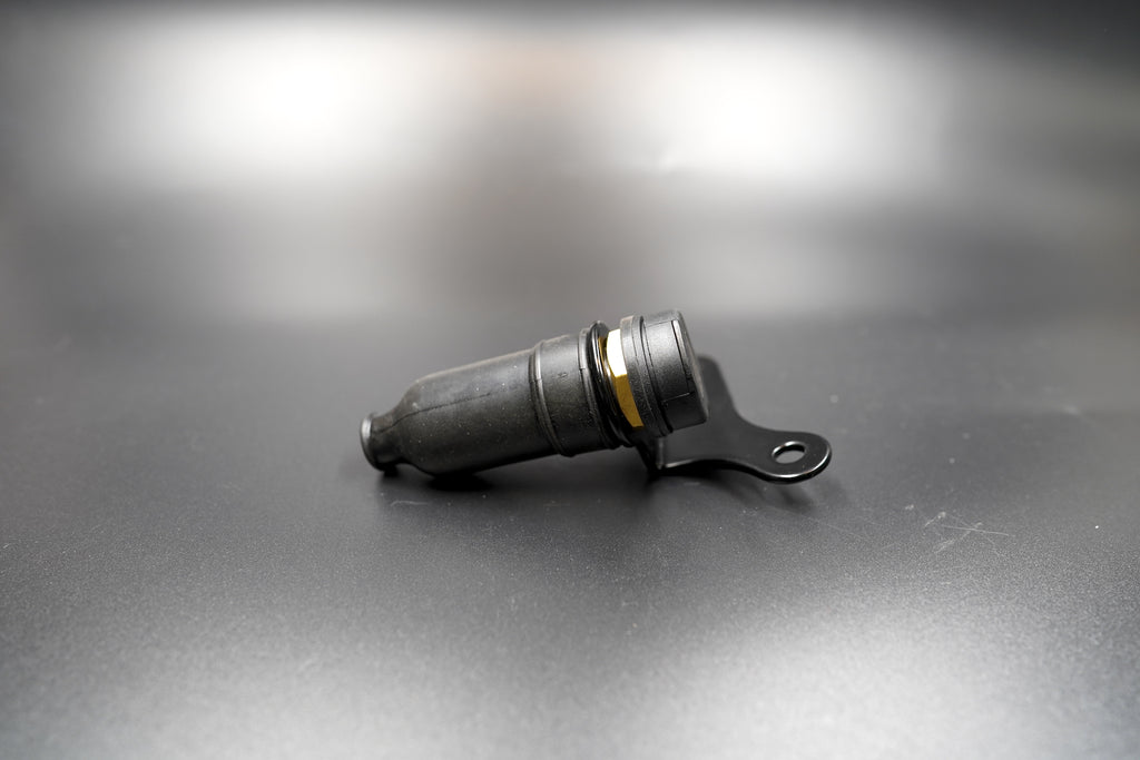 Auxiliary 12V power socket for Triumph Scrambler, laid flat on matte background