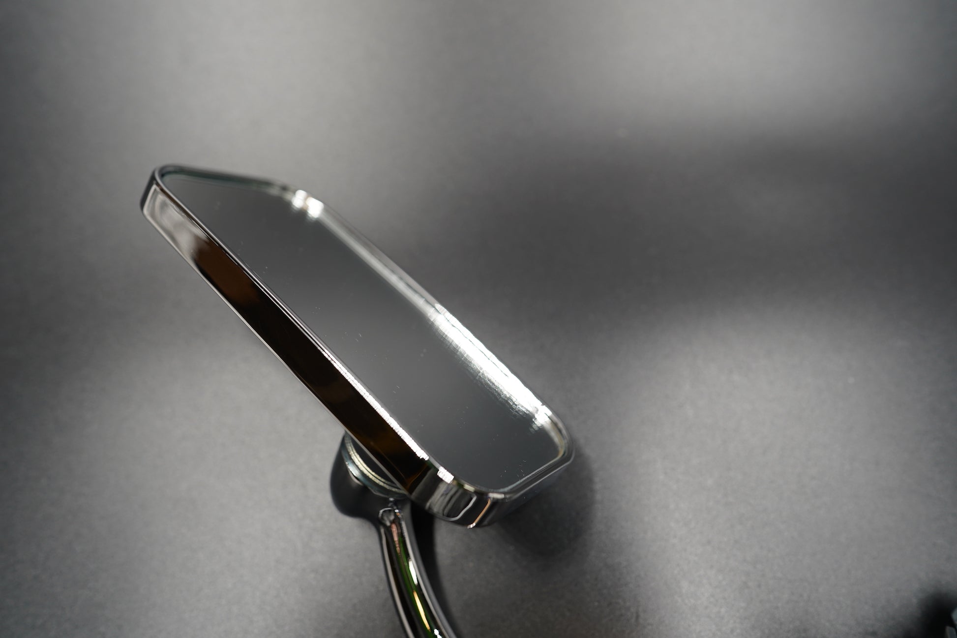 Mirror reflection detail — clear view and geometric symmetry against brushed metal surface.shot