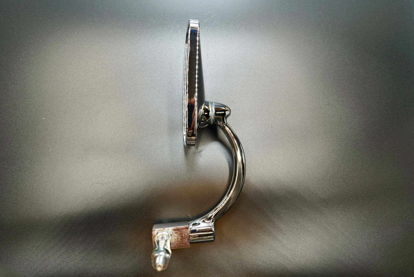 Side profile of universal bar-end motorcycle mirror — smooth aluminium stem and brushed metal surface.