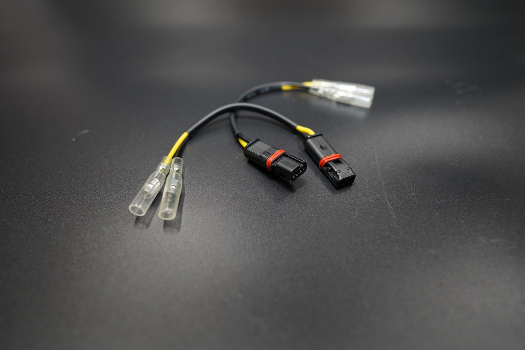 Close-up of BMW R NineT LED turn signal connectors showing OEM-fit terminals and wiring detail 