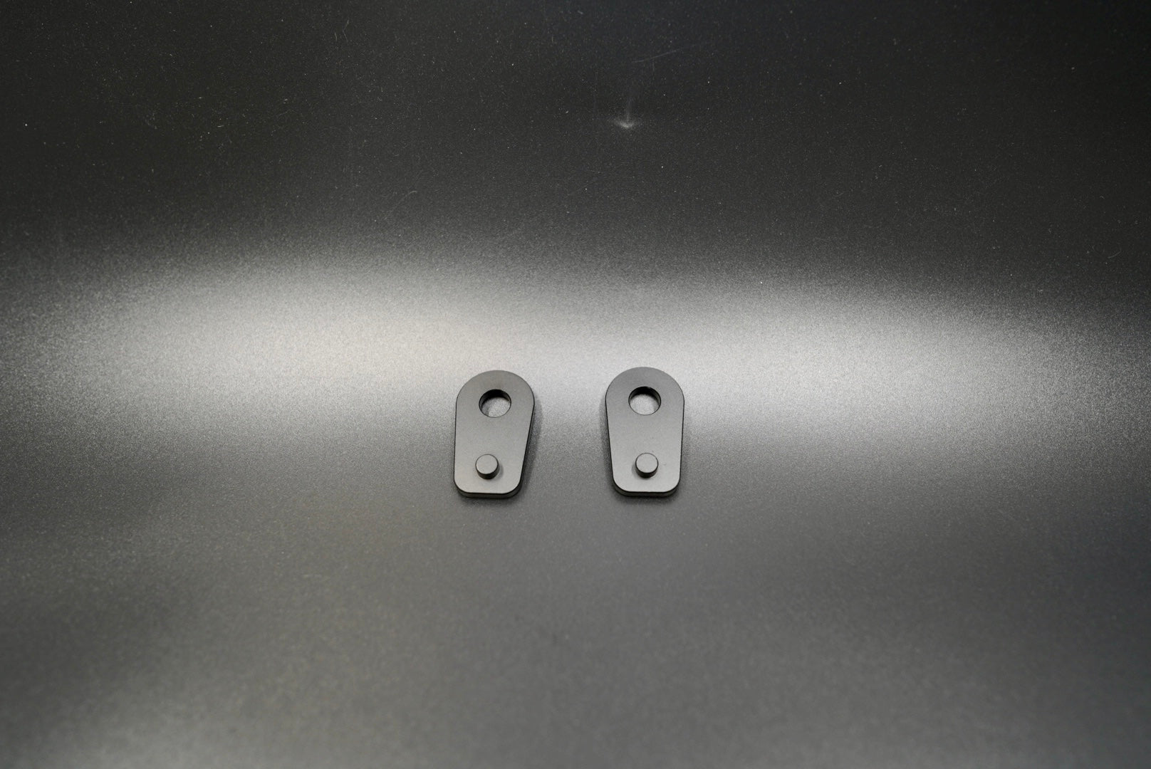 BMW R NineT aluminum turn signal spacers with black anodized finish on metallic surfac