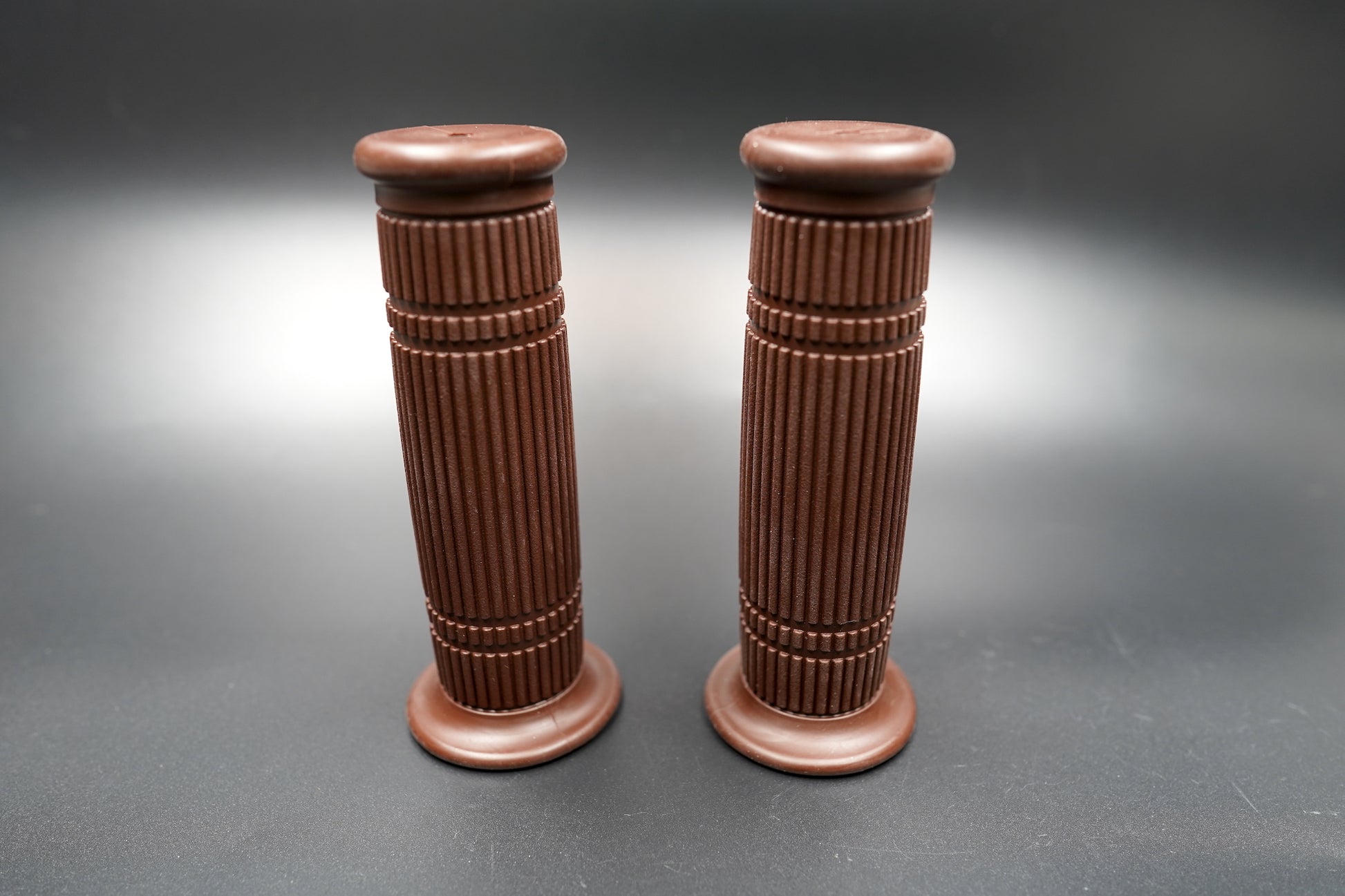 Pair of brown grips standing upright — balanced form and durable rubber compound for long rides.