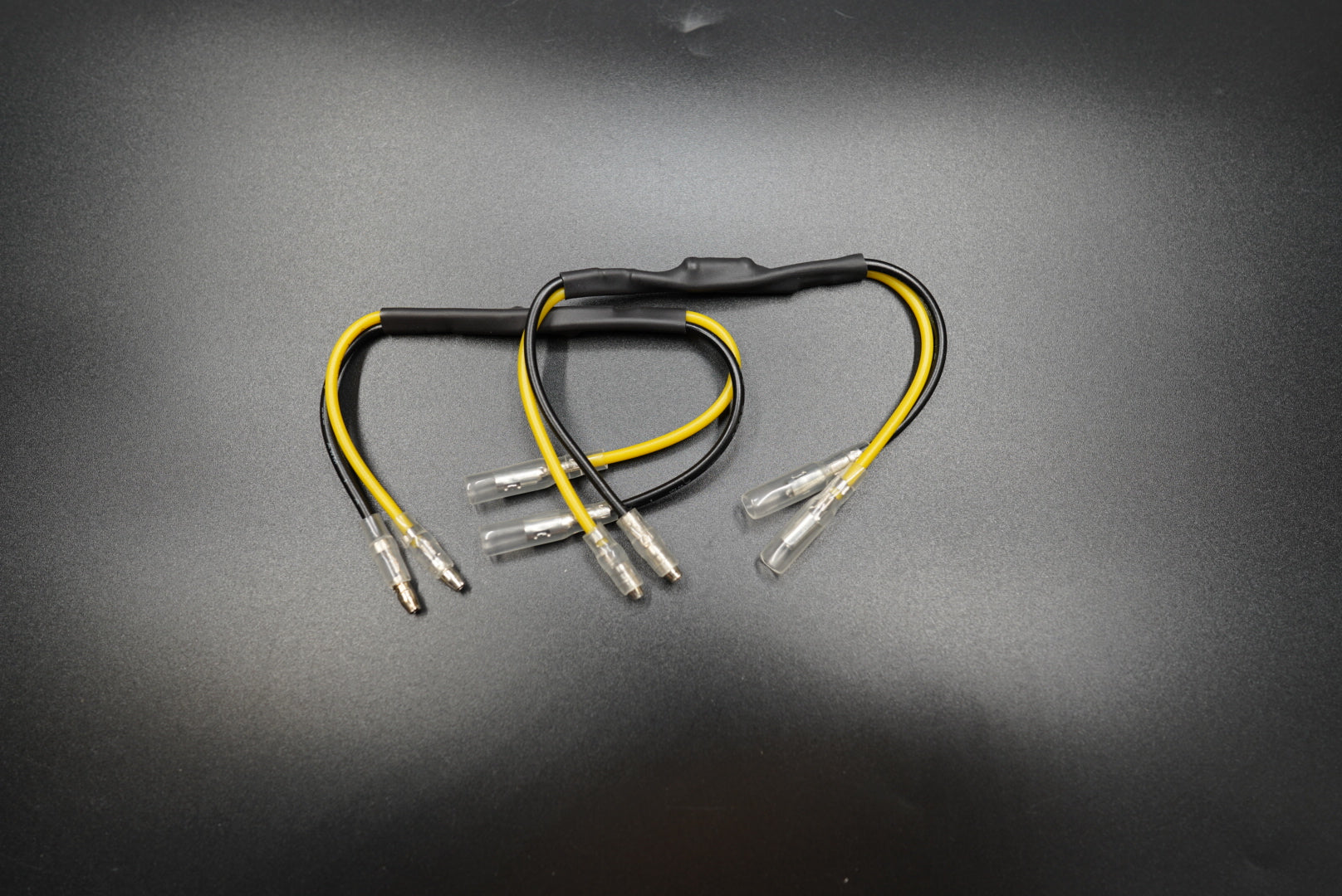Pair of CANBUS resistors with black and yellow wiring for Triumph LED turn signal upgrades, displayed on metallic background