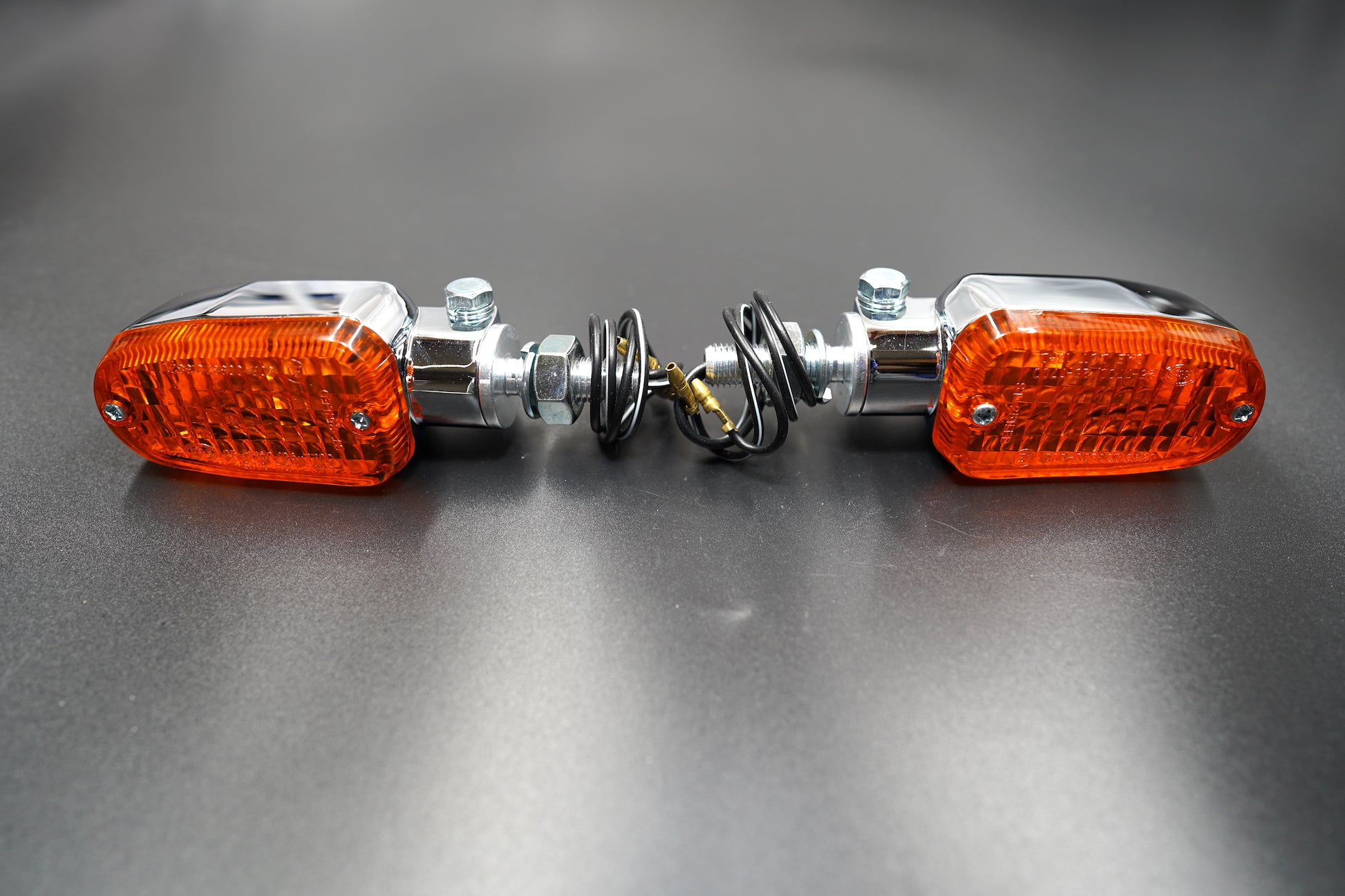 Front view of rectangular chrome LED turn signals with amber lenses — clean, classic motorcycle indicators.