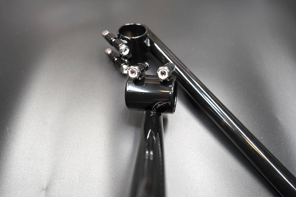 Flat lay of handlebar set arranged diagonally on grey matte background.
