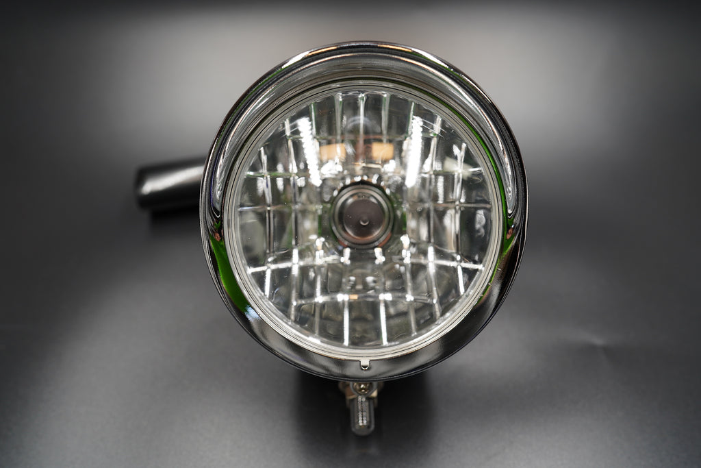 Front view showing clear patterned glass lens with grid reflector for precise light focus.