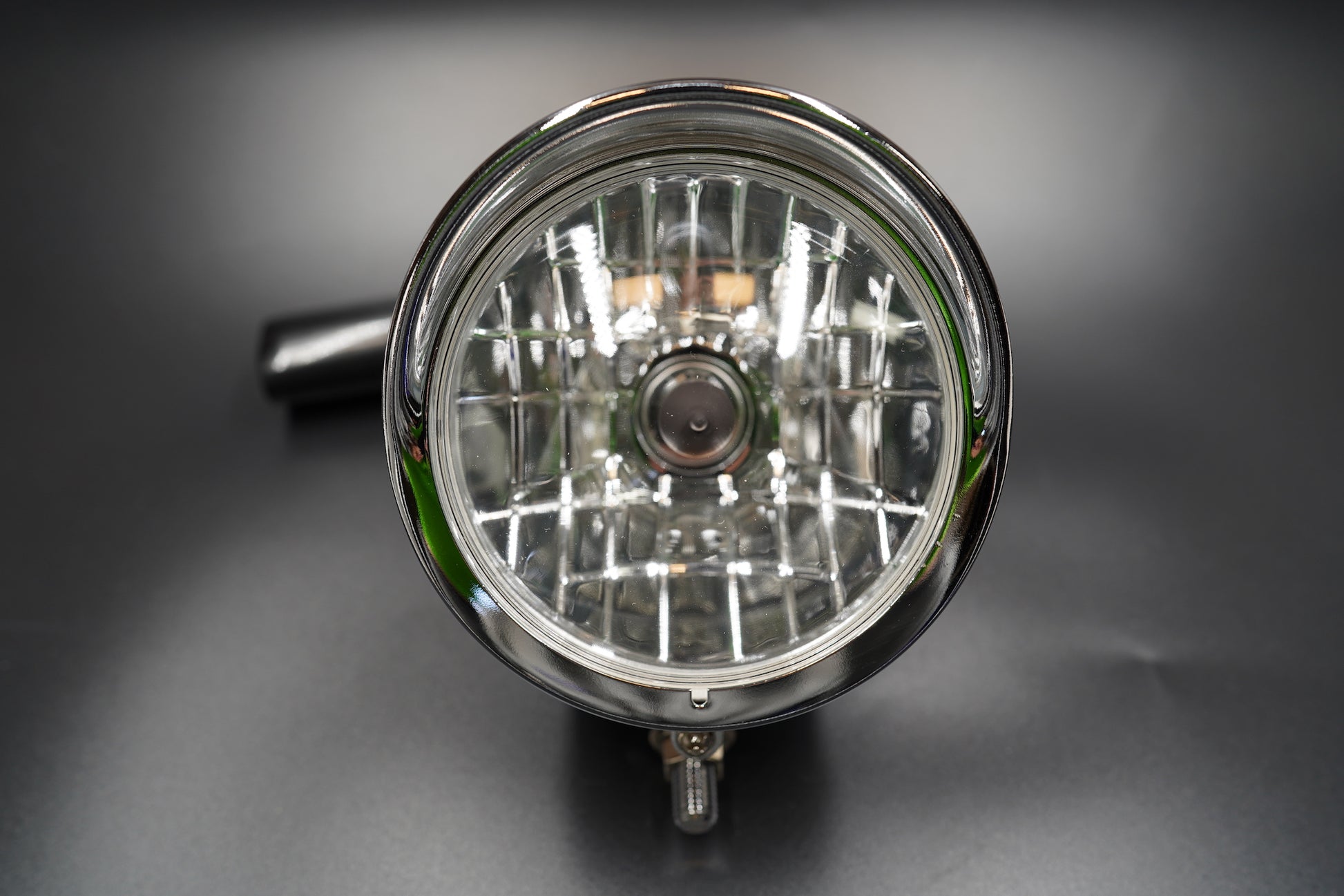 Front view showing clear patterned glass lens with grid reflector for precise light focus.