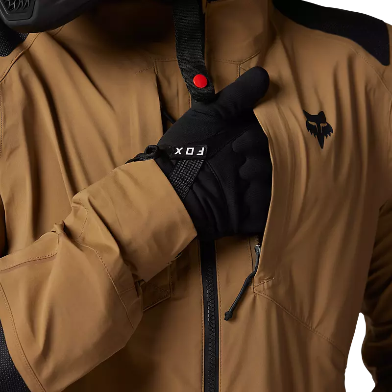 Rider wearing gloves adjusting Fox Recon GORE-TEX ADV Jacket sleeve — seamless riding integration.