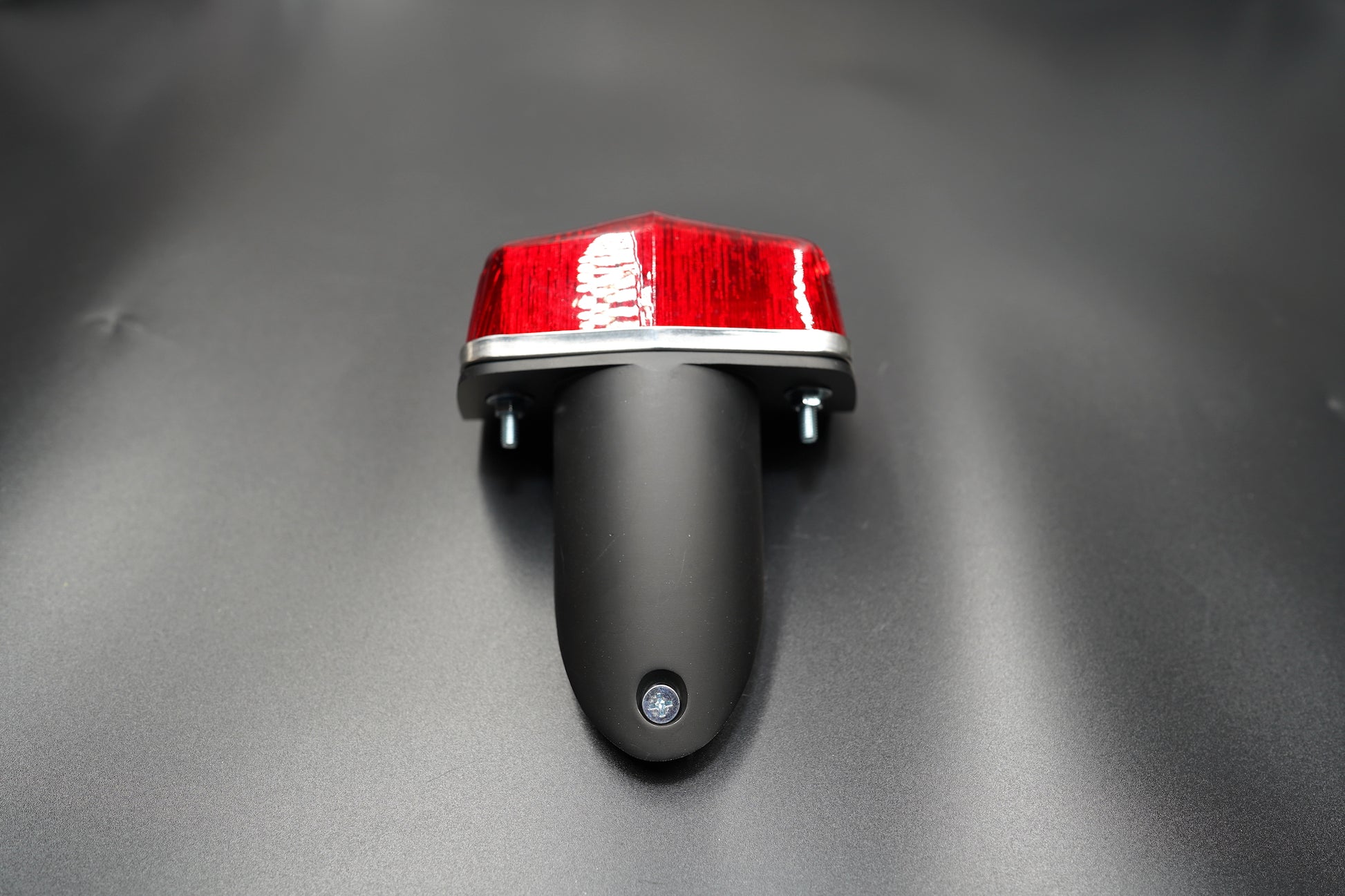 Top view of the classic Lucas-style tail light — polished silver trim contrasts with matte black bracket.