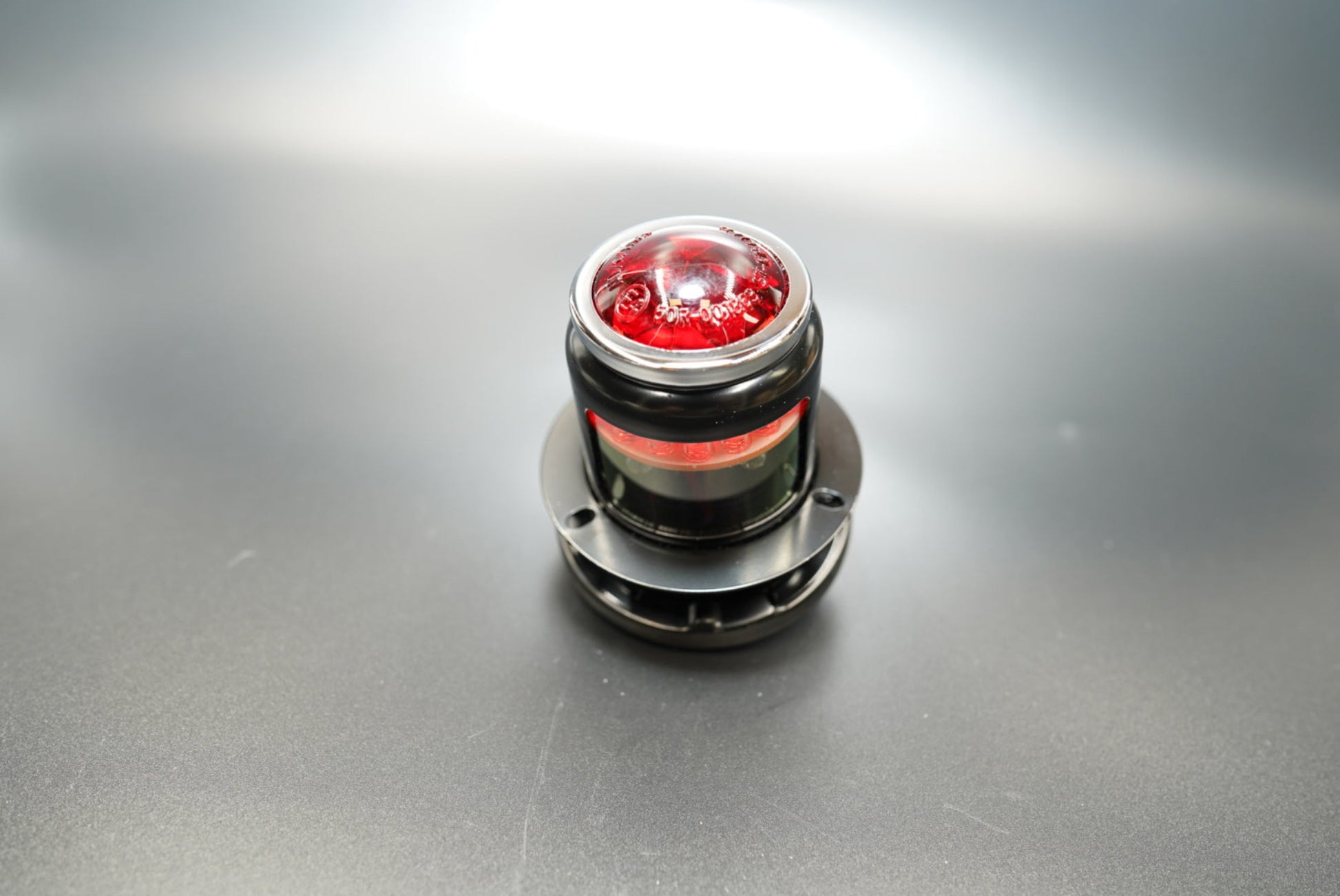 Front angled view of Lucas MT110-style motorcycle tail light — classic vintage rear light with red domed lens.