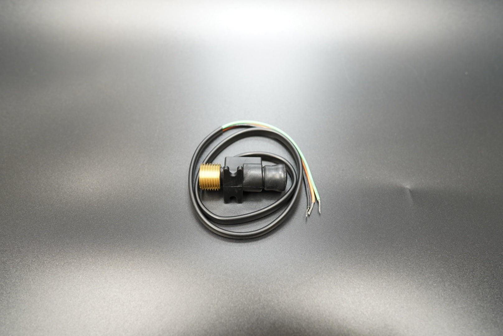 12mm motorcycle mechanical-to-electronic speedometer converter, front angle view on matte background.