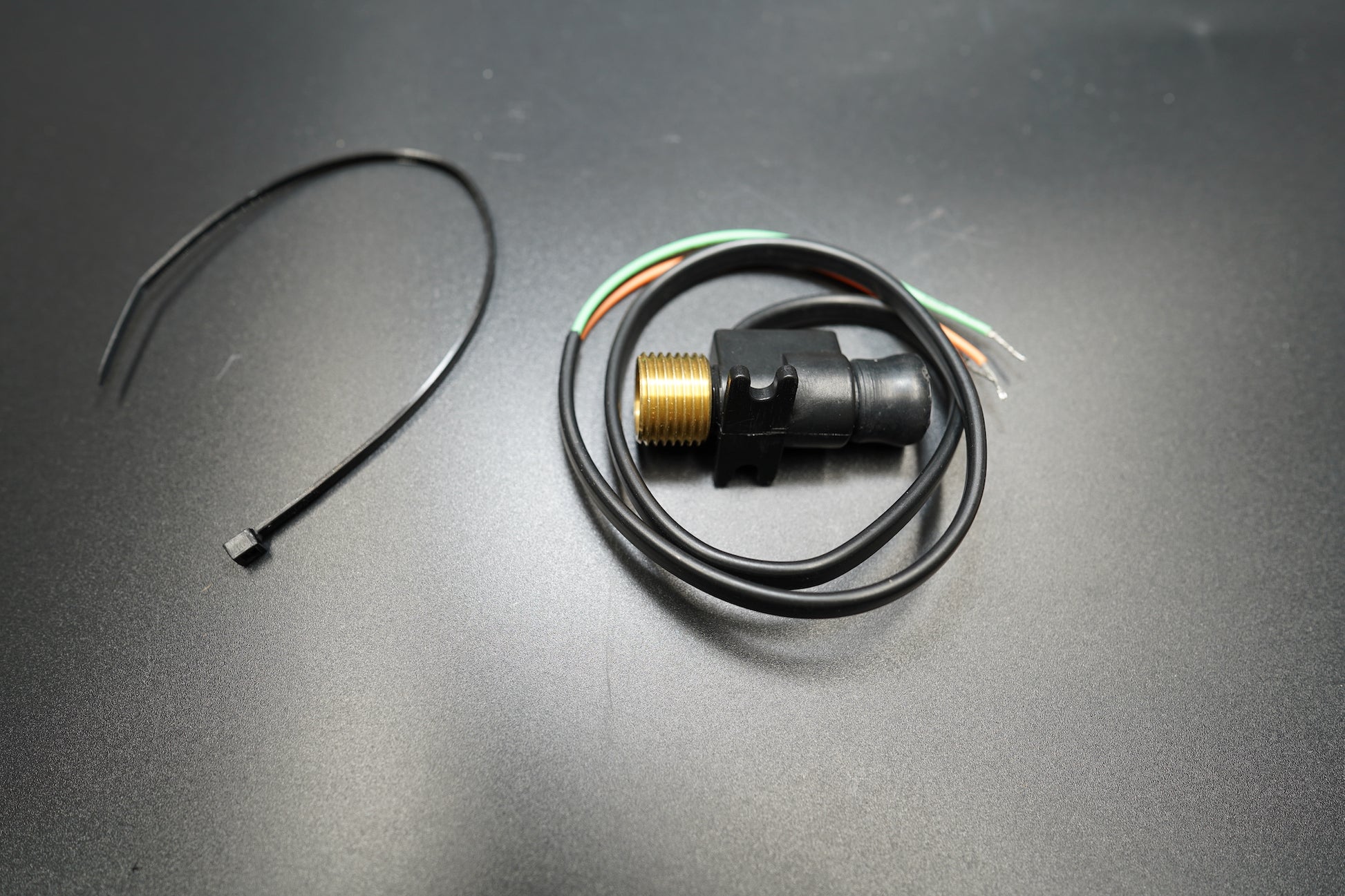 Top-down shot highlighting circular metal body and wiring tail.