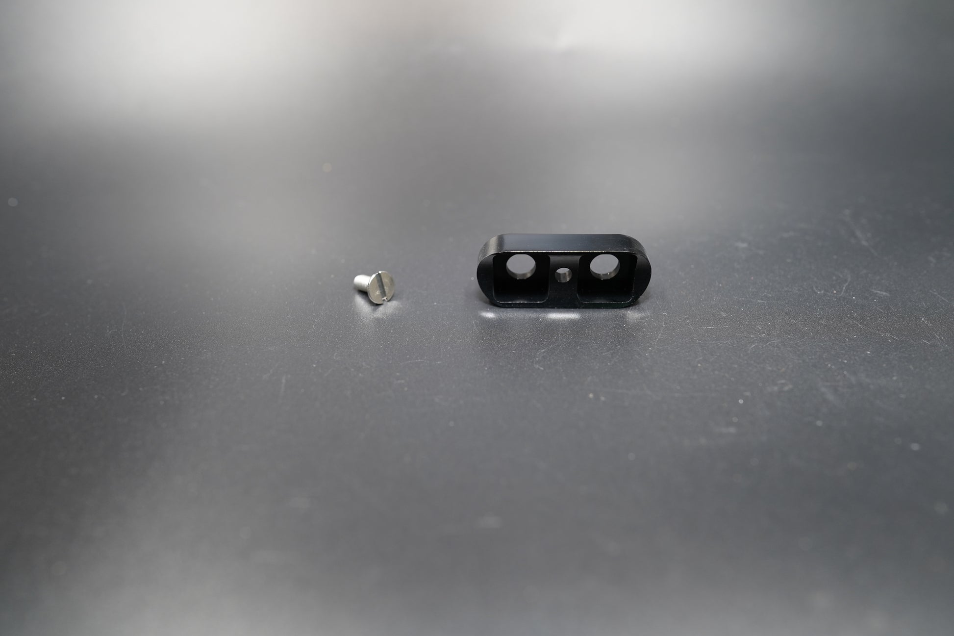 Top view of single-hole black mount with screw hardware