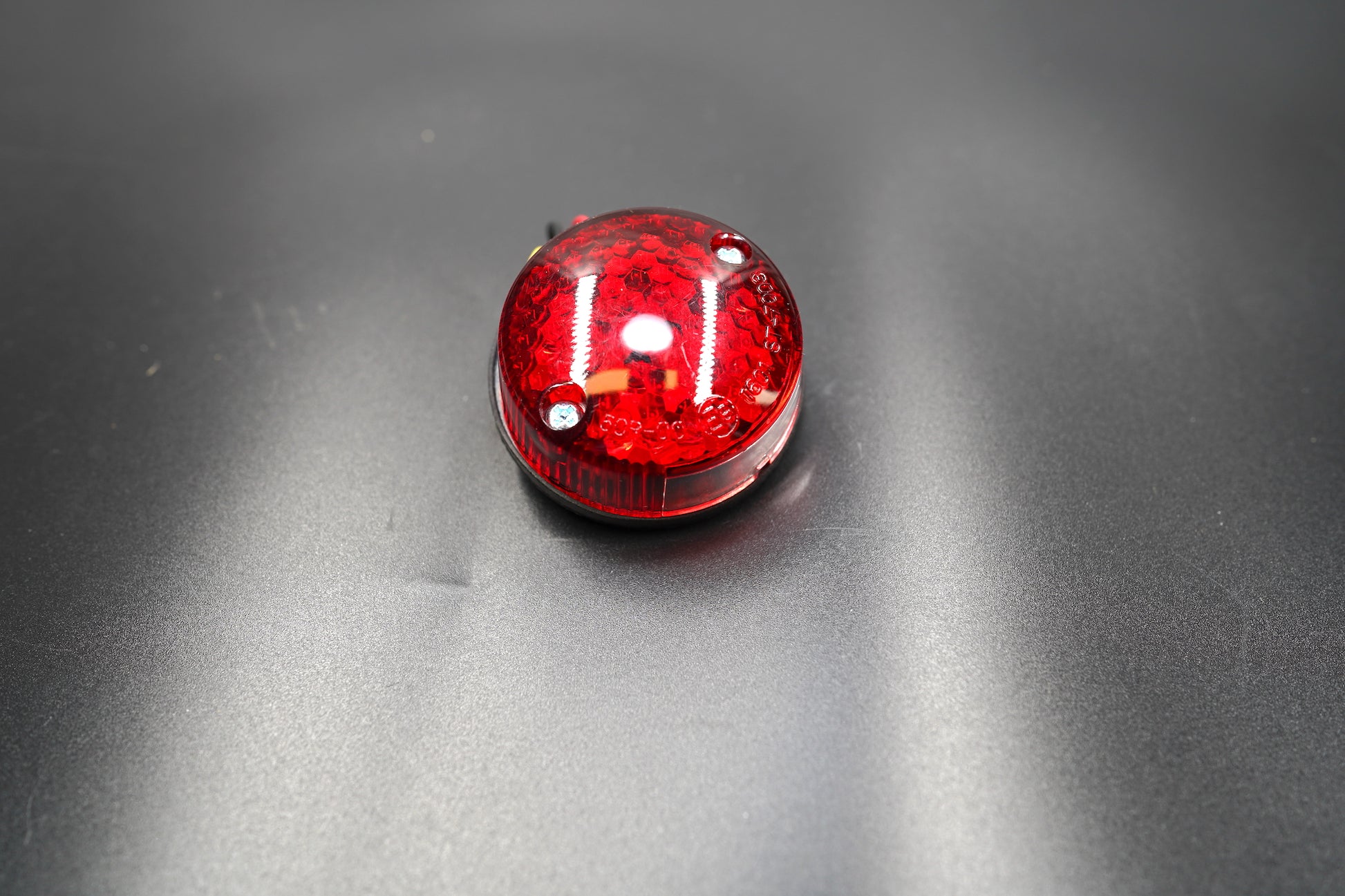Front main view of minimalist round LED tail light — compact red lens design for café racers and custom bikes.