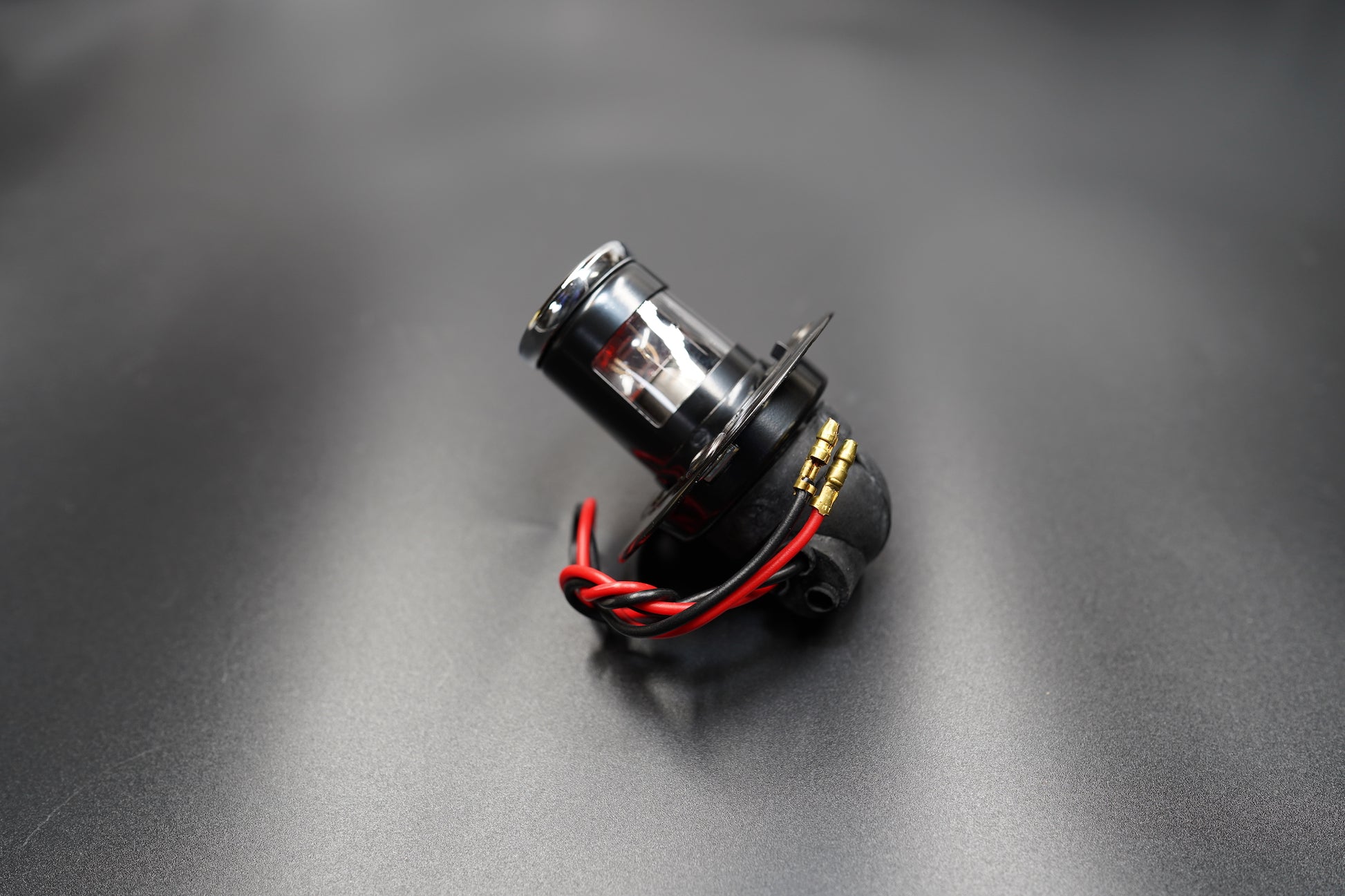 Close-up of diamond-cut red glass lens — rich vintage glow and reflection.