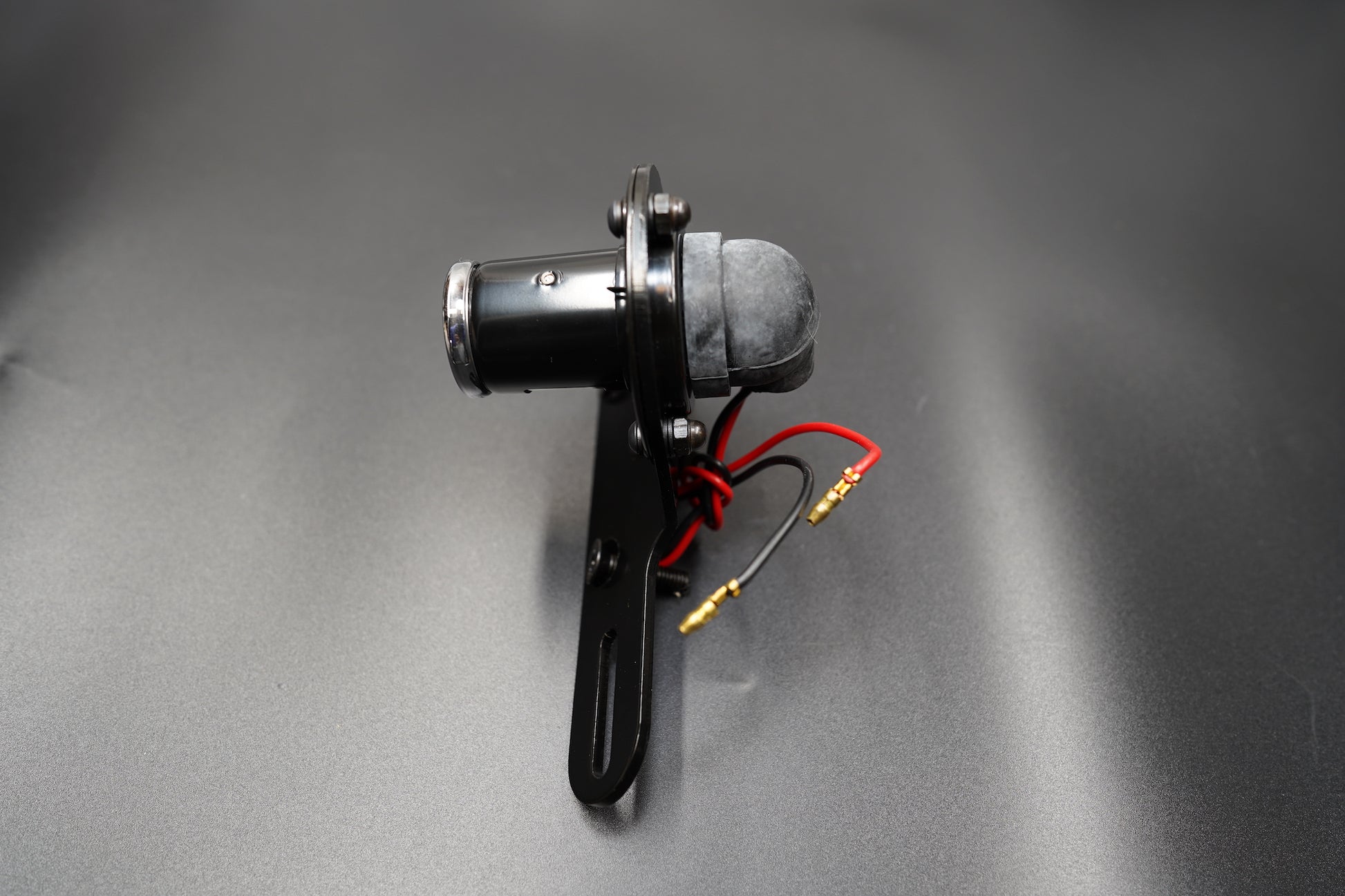 Left side profile showing curved housing and compact bracket form.