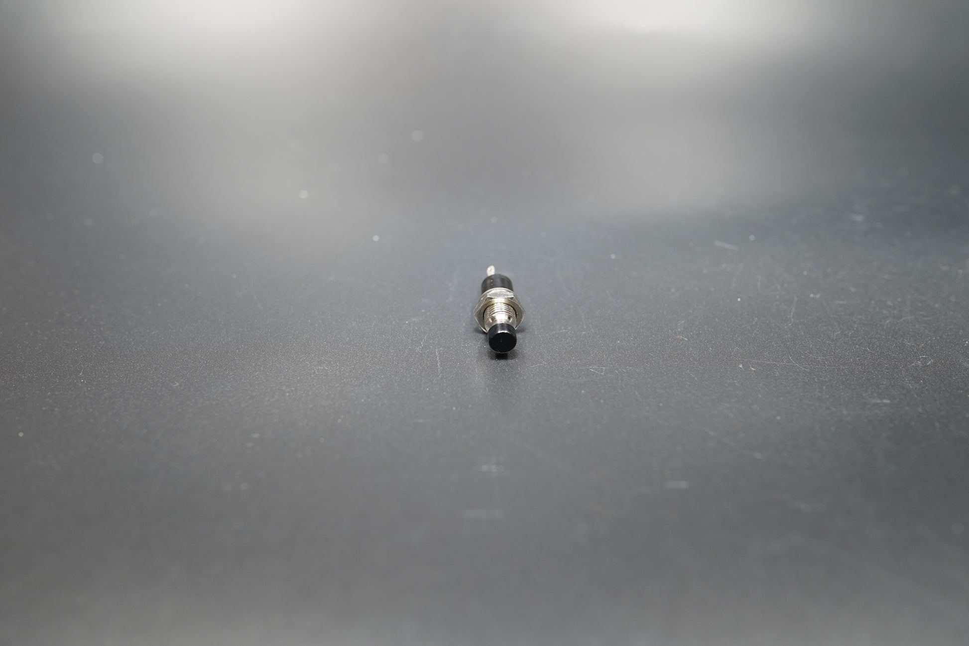 Black version of motorcycle push button switch on neutral background