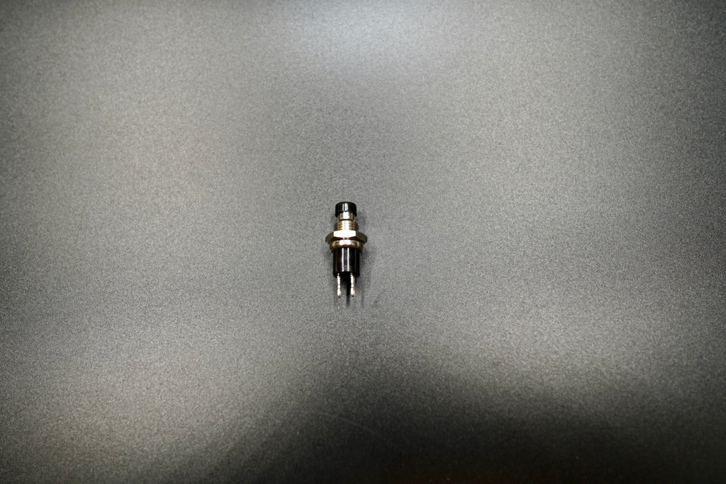 Push button motorcycle switch front view showing compact chrome housing