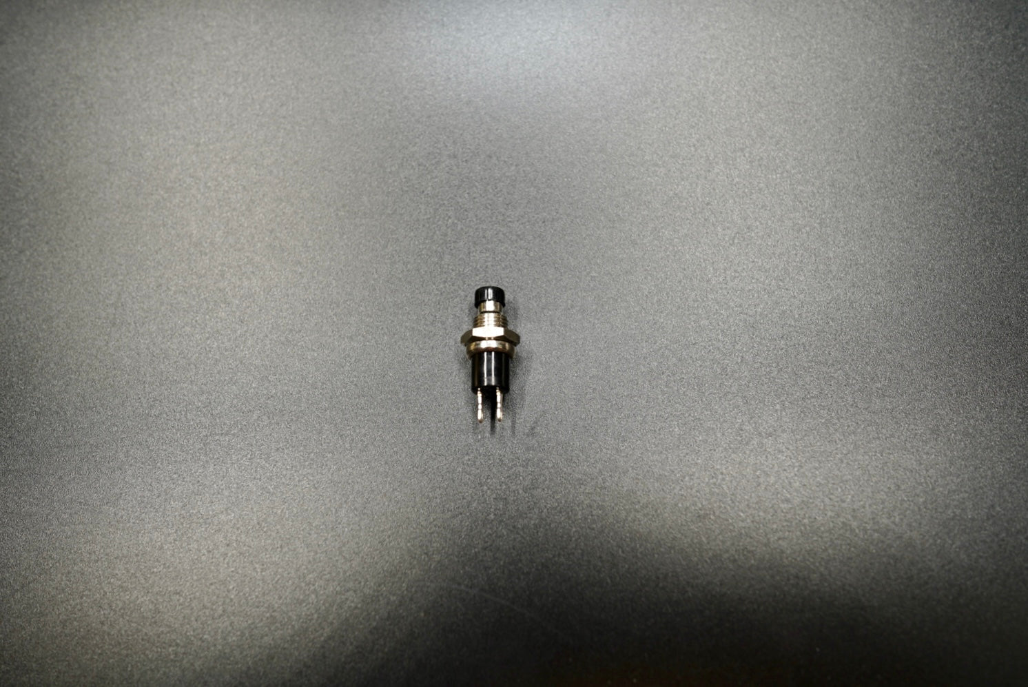 Push button motorcycle switch front view showing compact chrome housing