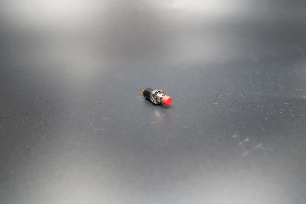 Close-up detail of red push button switch top 