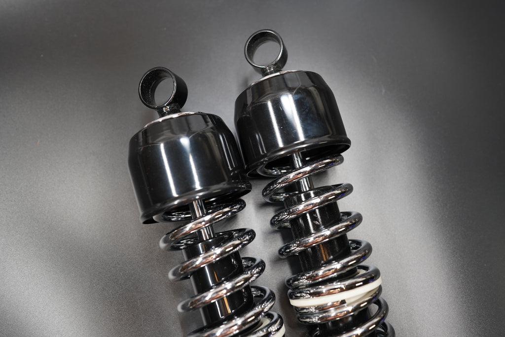 Bottom view focusing on the mounting eyes and chrome spring reflection.