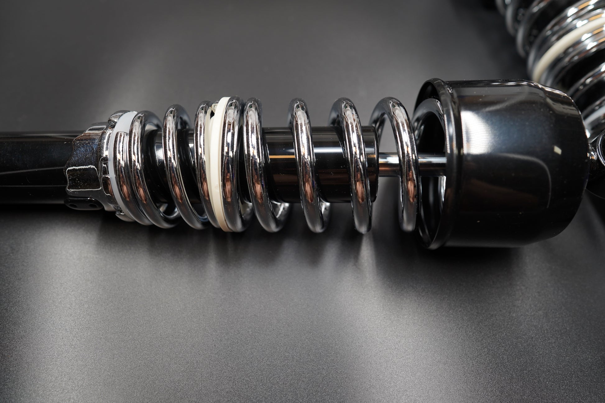 Flat lay of two classic rear shocks aligned side by side on matte grey background.