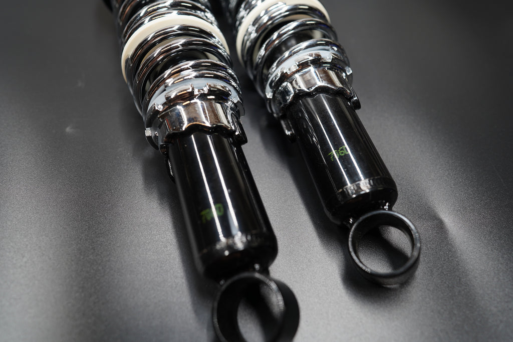 Close-up top angle showing polished coil springs and black damping body.