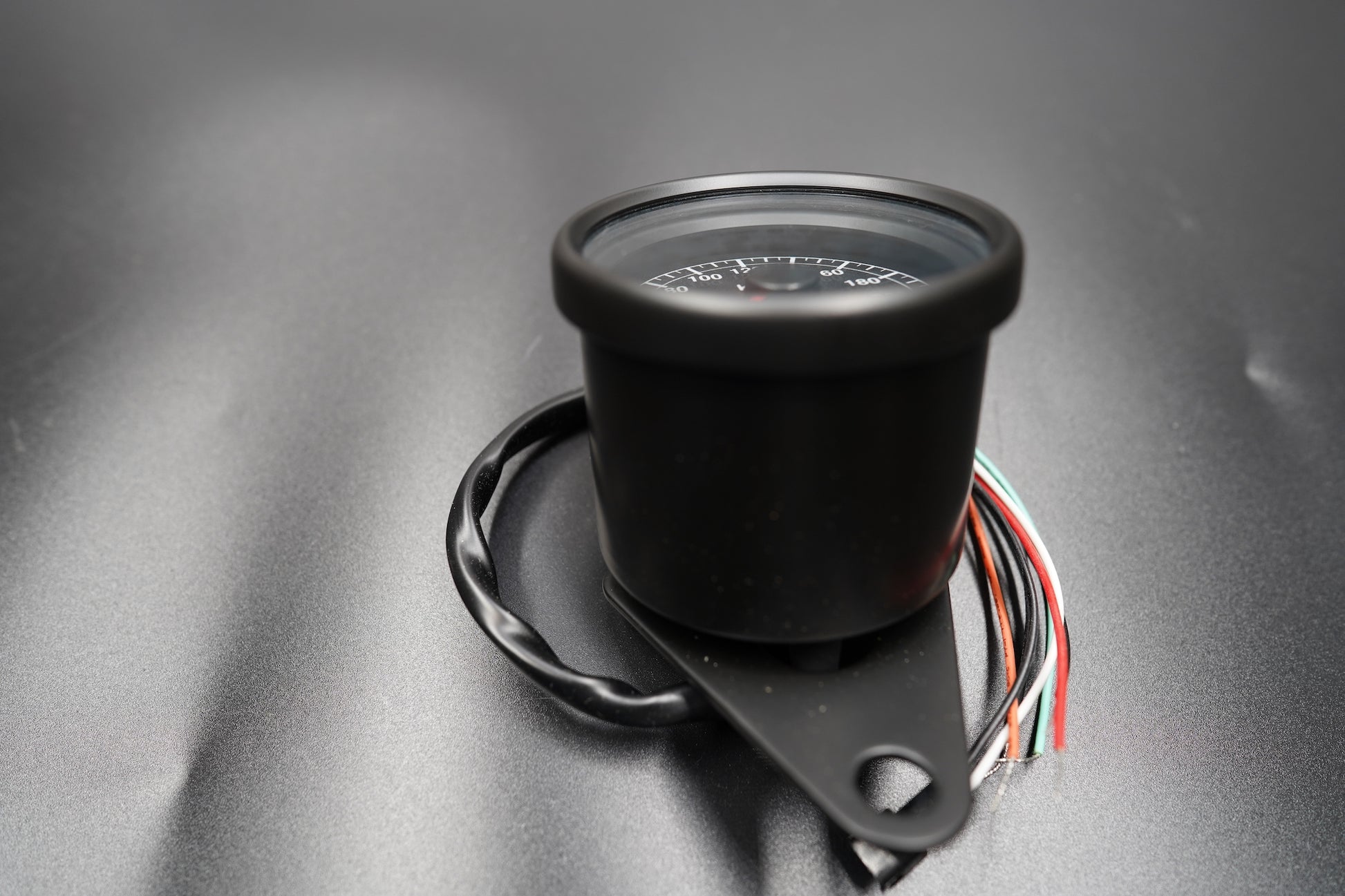 Top view of compact 60mm speedometer with classic black dial and chrome ring.