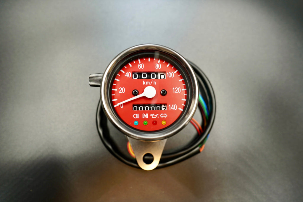 Red dial variant of classic motorcycle speedometer with stainless steel shell.