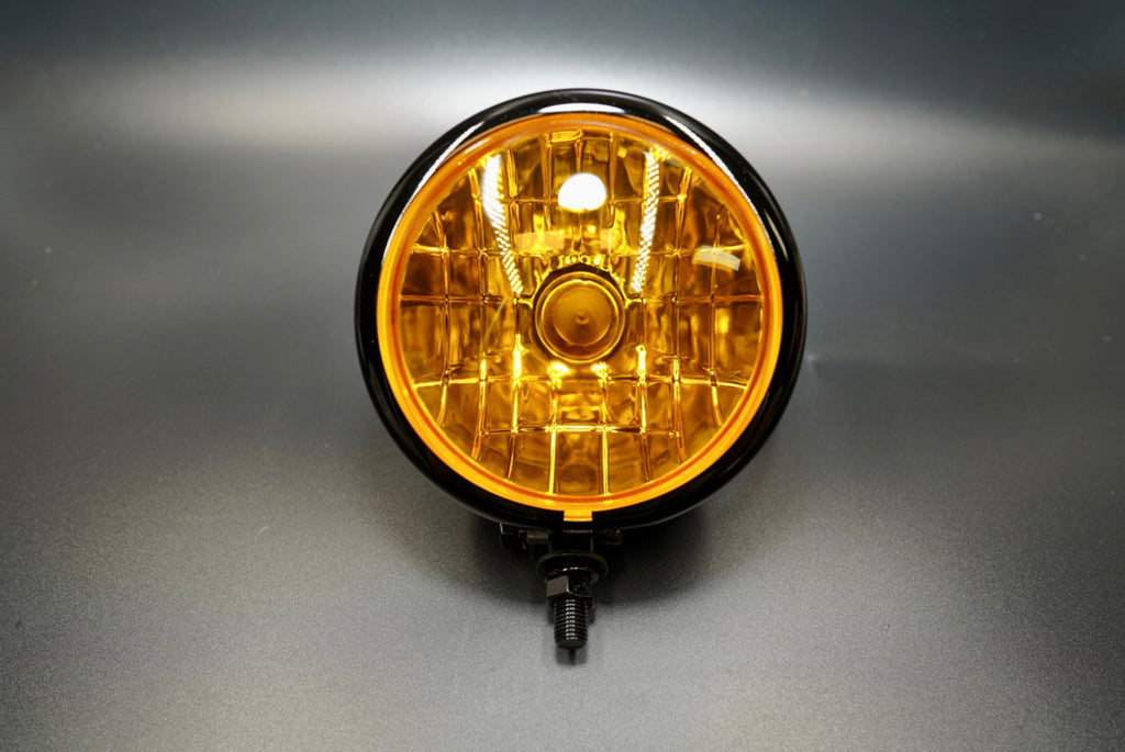Front view of 4.5-inch matte black motorcycle headlight with amber diamond-cut lens — classic retro design.