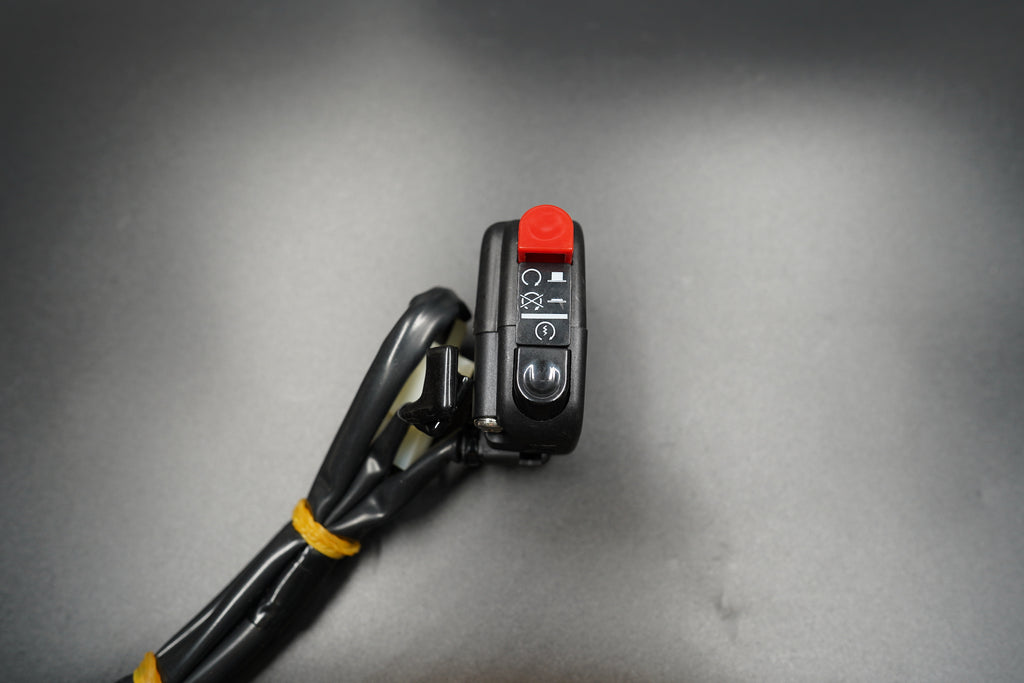 Angled shot focusing on texture of black plastic and red switch