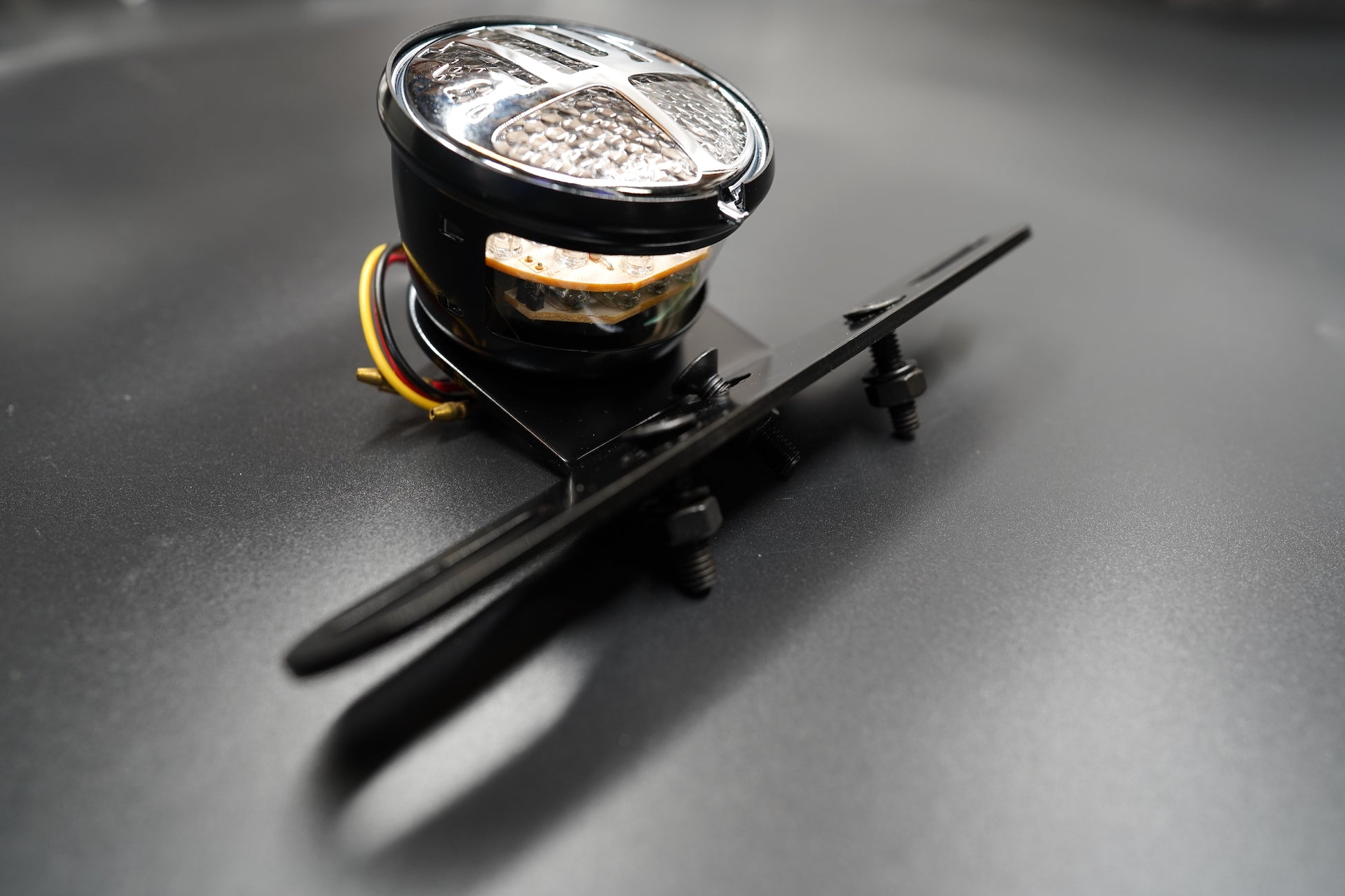 Top-down view of light and plate mount assembly on matte background.