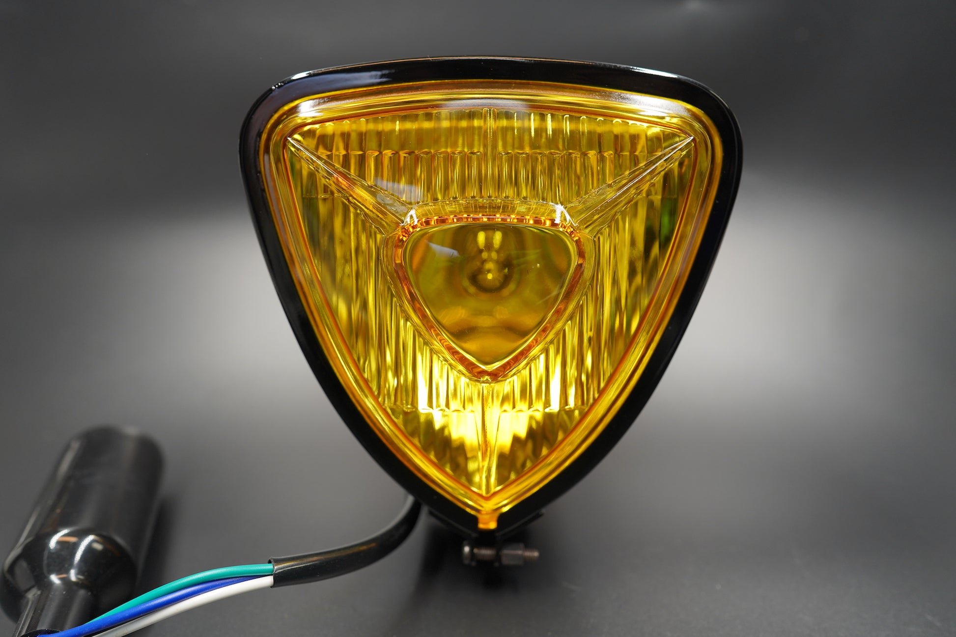 Close-up of amber triangular lens highlighting fine-cut glass and vintage glow