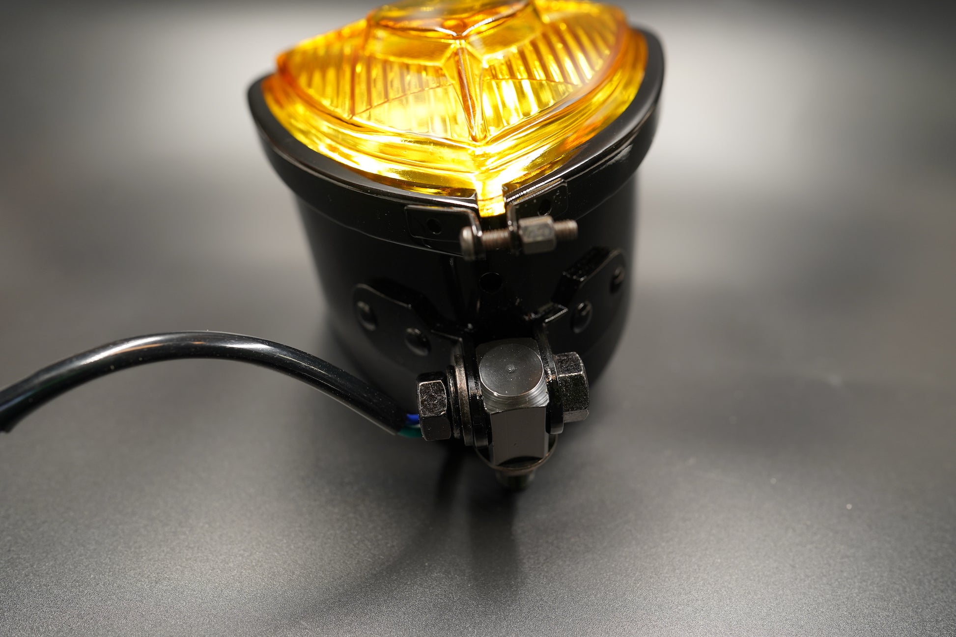 Amber version illuminated — warm tone under lighting, soft reflection.