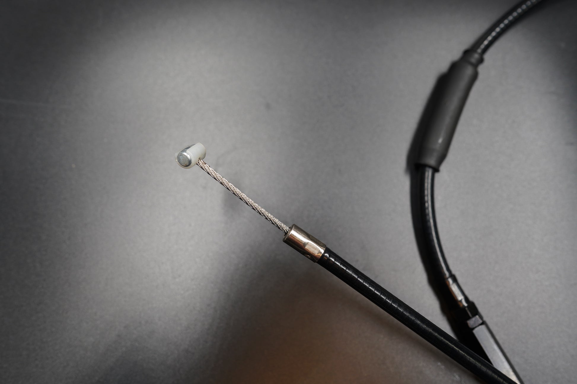 Macro view of Triumph Bobber clutch cable thread and protective sleeve