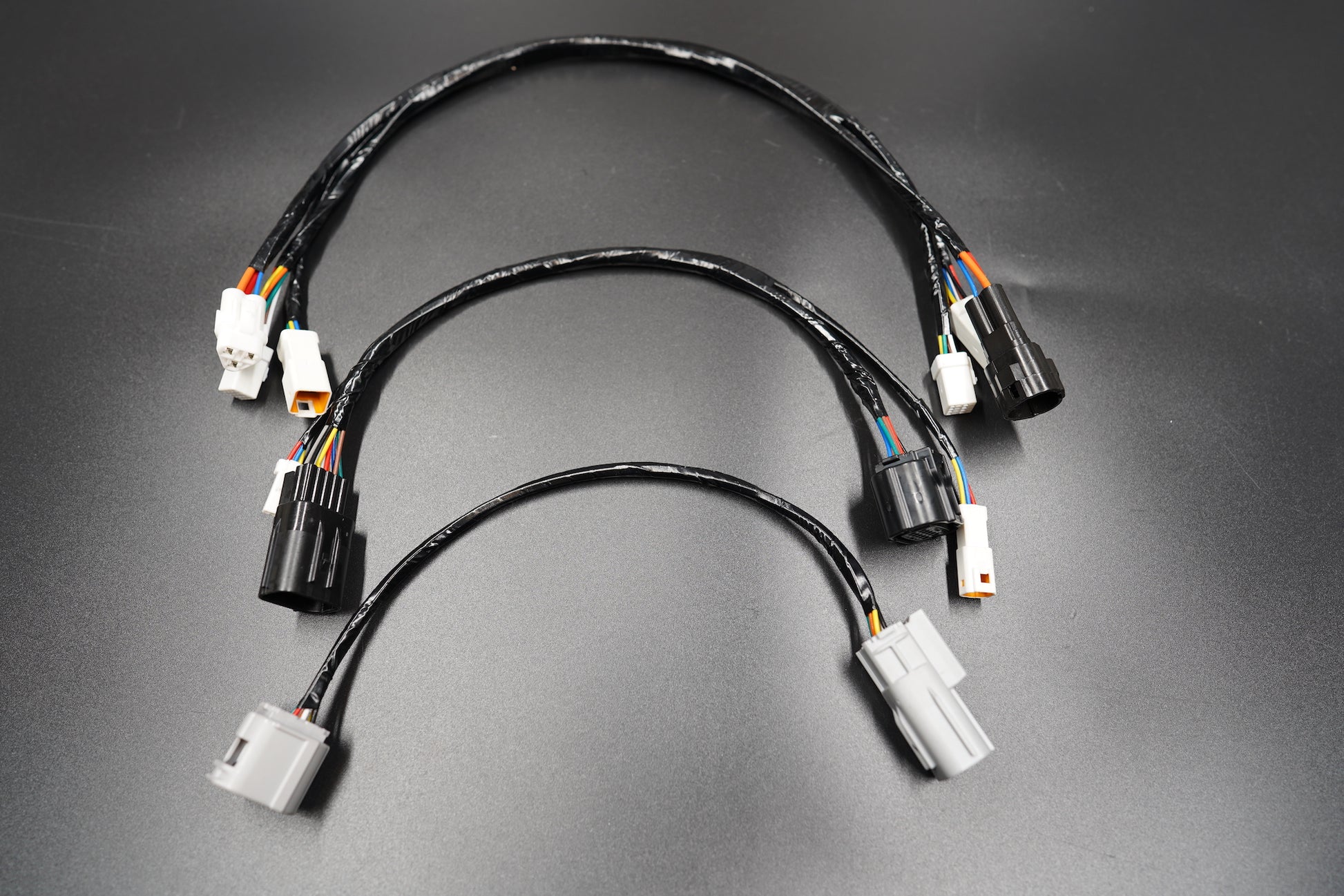 Triumph Bobber and Speedmaster wiring extension kit 3-line set arranged on matte black surface