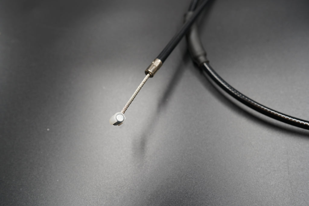 Close-up of Triumph T120/T100 extended clutch cable tip and sheath on matte surface