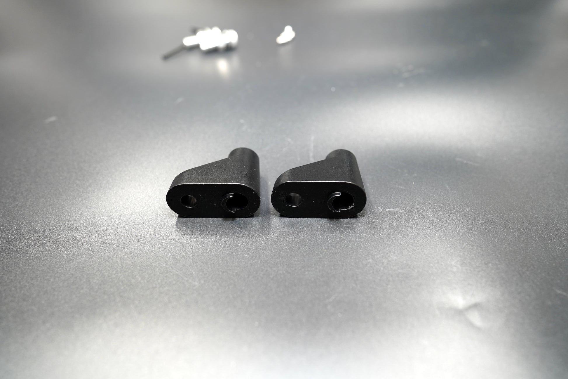 Close-up view of Triumph turn signal spacers showing matte black anodized finish