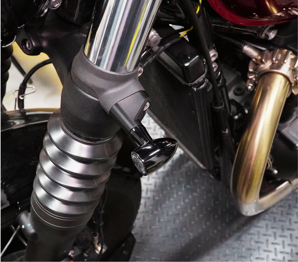 Triumph front fork setup featuring installed black aluminum turn signal spacers 