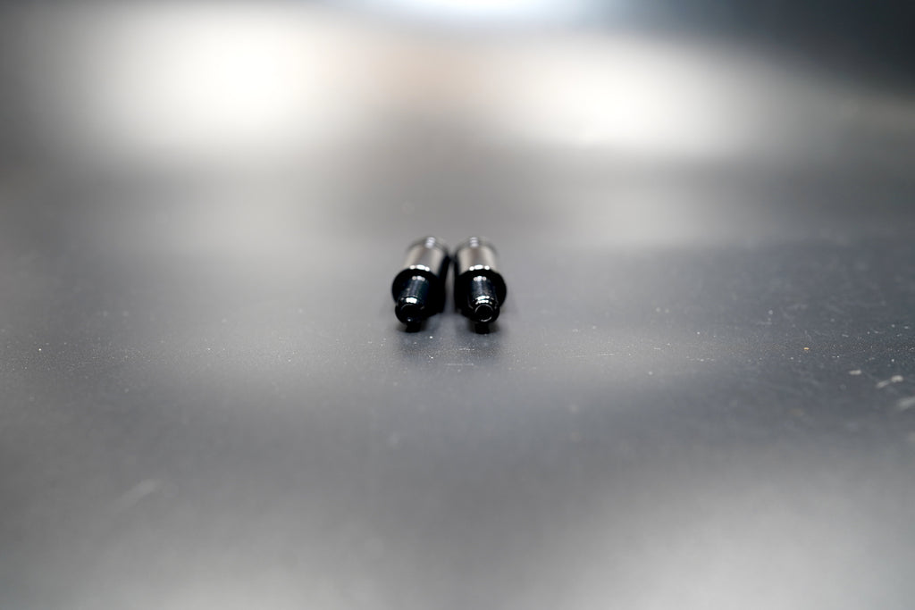 Side view of Triumph turn signal extension rods showing threaded ends and smooth matte finish