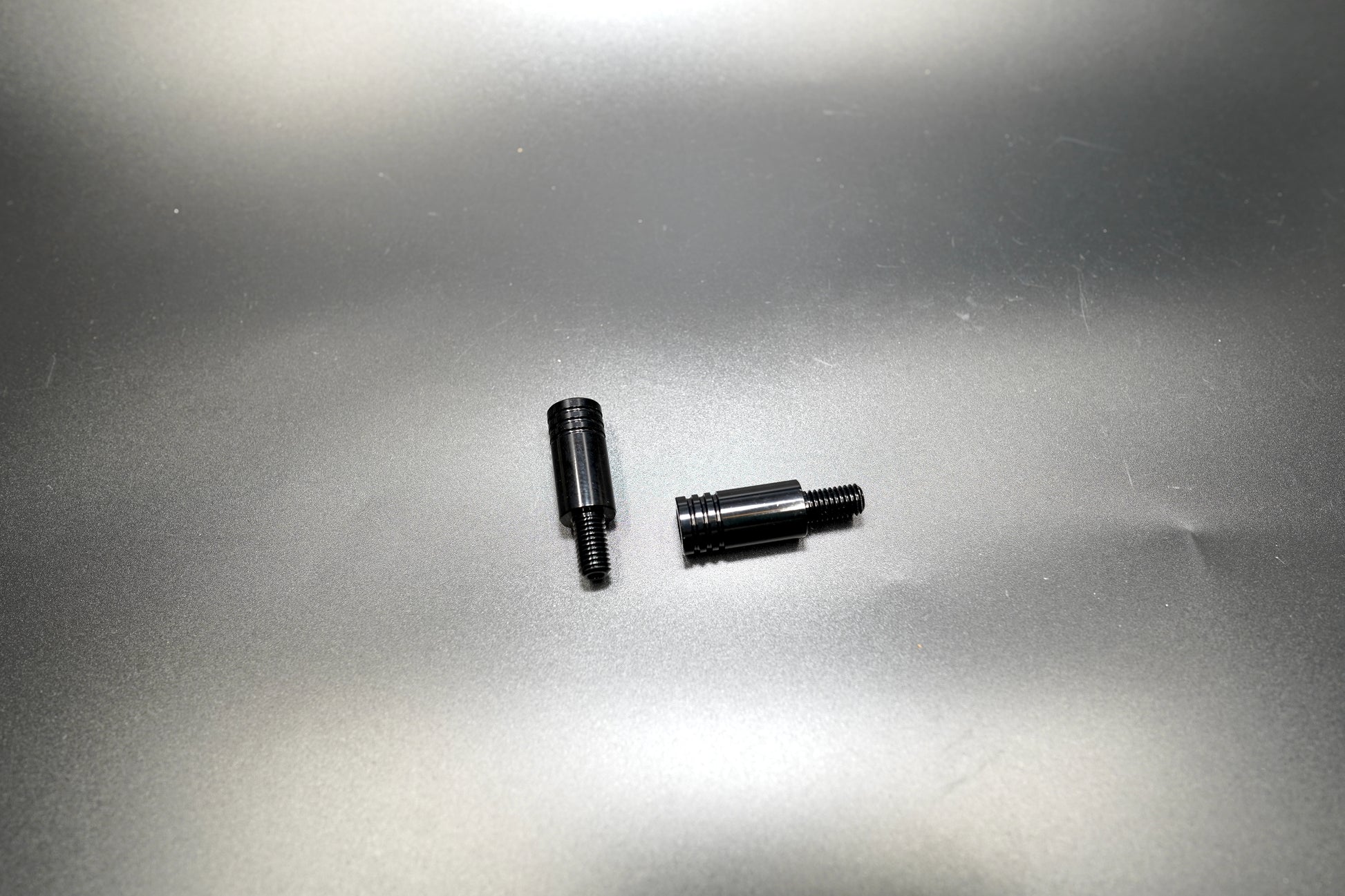 Pair of matte black 3cm turn signal extension rods with 8mm thread, displayed on metallic background
