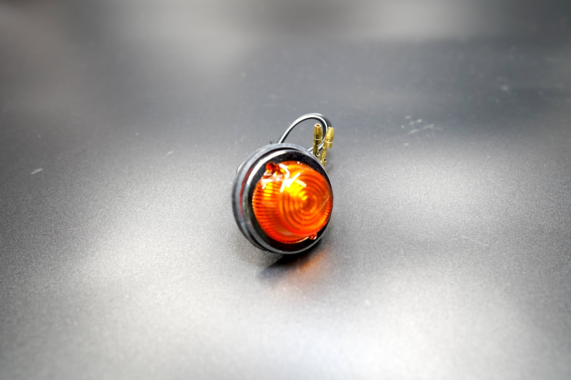 Side angle showing amber lens and chrome bezel — classic look for café racers and bobbers.