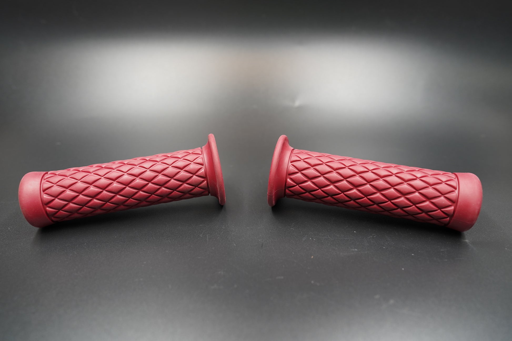 Angled top-down view of red grips laying crossed on matte background