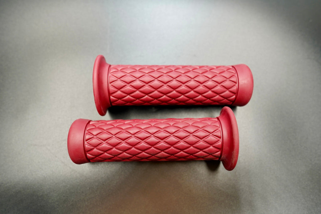 Pair of vintage red motorcycle grips with diamond tread pattern 